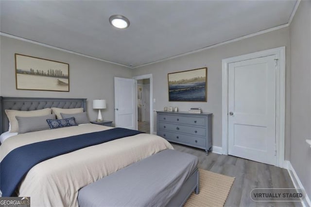 bedroom with hardwood / wood-style floors and ornamental molding