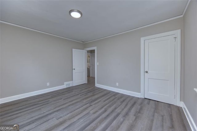 unfurnished room with light wood-type flooring and ornamental molding