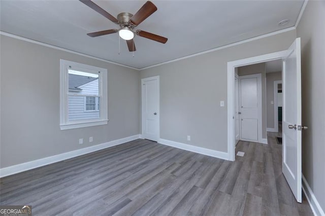 spare room featuring hardwood / wood-style flooring, ceiling fan, and ornamental molding