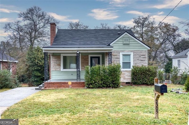 bungalow-style house featuring a front yard and covered porch