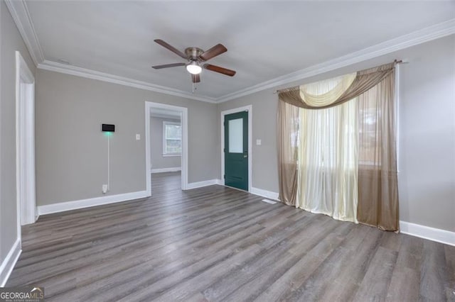 empty room featuring wood-type flooring, ceiling fan, and crown molding