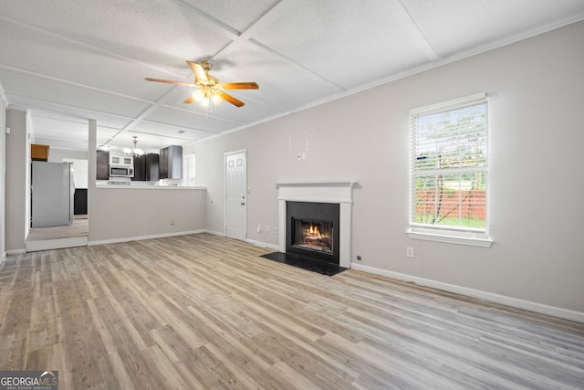 unfurnished living room featuring ceiling fan with notable chandelier, light hardwood / wood-style floors, a textured ceiling, and coffered ceiling