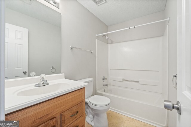 full bathroom with tile patterned floors, a textured ceiling, toilet, shower / washtub combination, and vanity