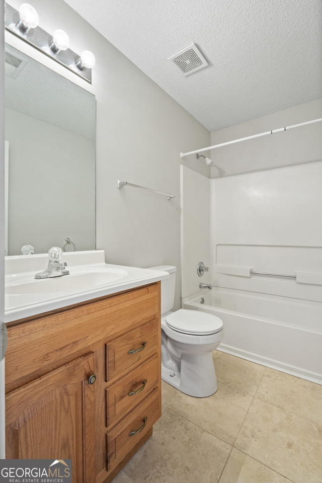 full bathroom with tile patterned flooring, a textured ceiling, toilet, vanity, and bathtub / shower combination