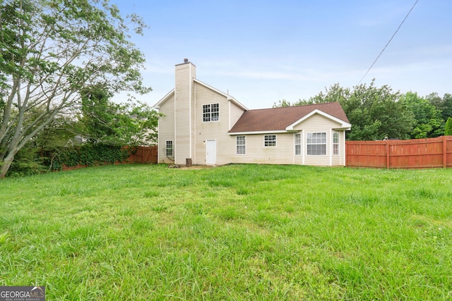 rear view of house featuring a lawn