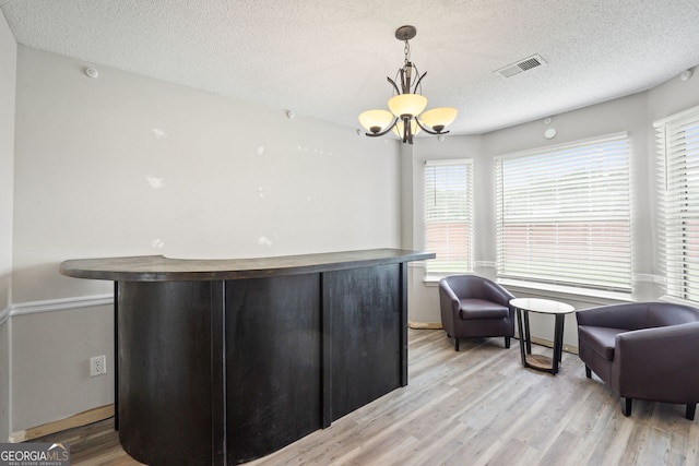 sitting room featuring a chandelier, a textured ceiling, and light wood-type flooring