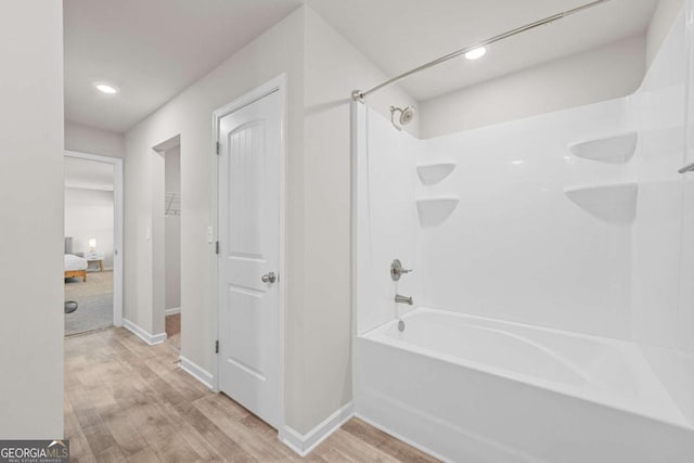 bathroom featuring hardwood / wood-style floors and bathing tub / shower combination