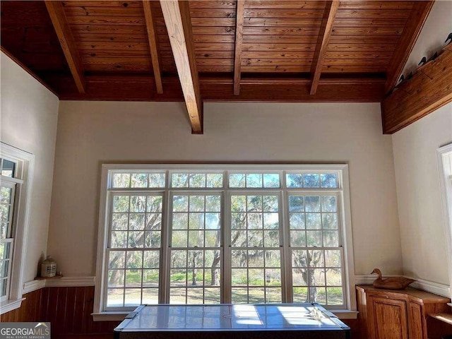 entryway with wooden walls, wood ceiling, and vaulted ceiling with beams