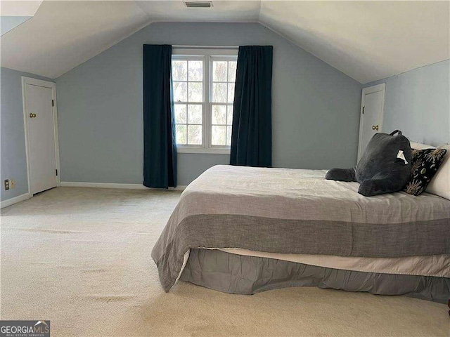 bedroom with light carpet and lofted ceiling