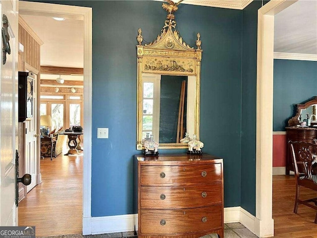 hall with hardwood / wood-style floors, crown molding, and french doors