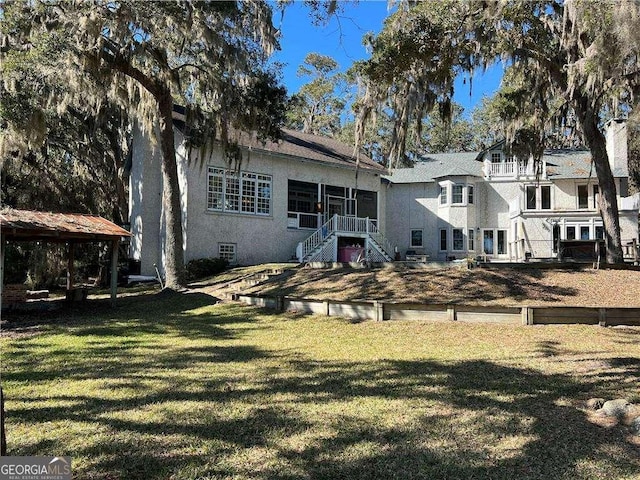 rear view of house with a gazebo and a yard