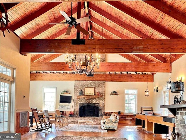 living room with a healthy amount of sunlight, a fireplace, and beamed ceiling