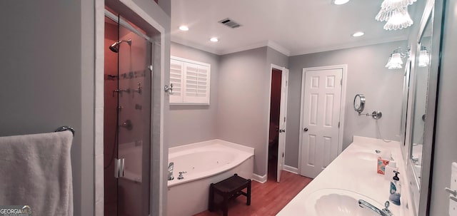 bathroom featuring hardwood / wood-style flooring, vanity, ornamental molding, and plus walk in shower