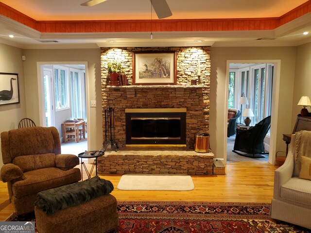 1030 Lake Haynes Dr NE, Conyers, GA 30012 - living area with a tray ceiling, wood finished floors, ornamental molding, a fireplace, and ceiling fan