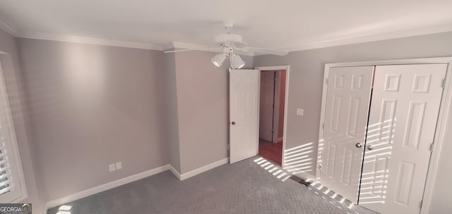 interior space with dark colored carpet, ceiling fan, ornamental molding, and a closet