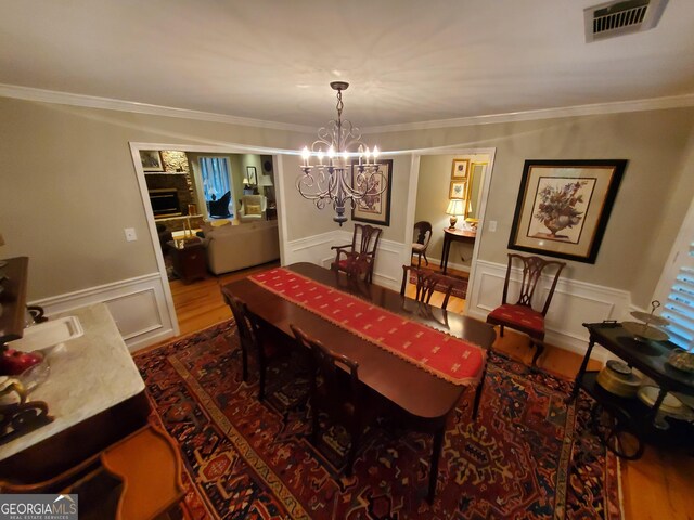 1030 Lake Haynes Dr NE, Conyers, GA 30012 - dining room featuring wood finished floors, visible vents, ornamental molding, and an inviting chandelier