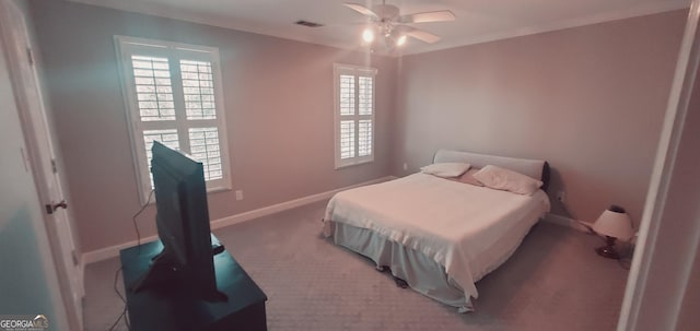 bedroom with carpet flooring, ceiling fan, and crown molding