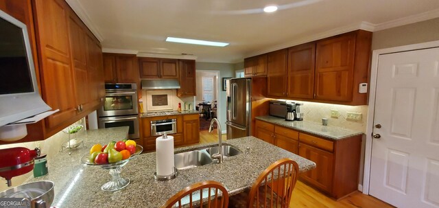 1030 Lake Haynes Dr NE, Conyers, GA 30012 - kitchen with brown cabinets, appliances with stainless steel finishes, under cabinet range hood, and a sink