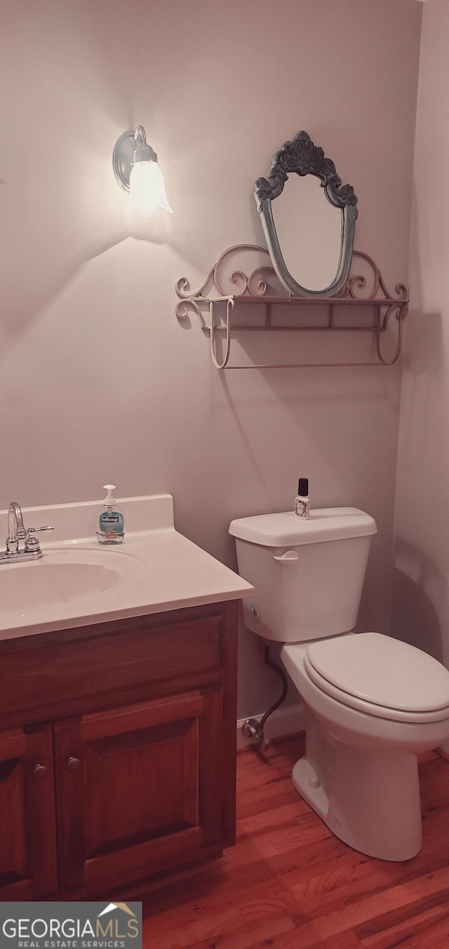 bathroom featuring hardwood / wood-style floors, vanity, and toilet