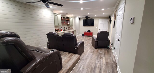1030 Lake Haynes Dr NE, Conyers, GA 30012 - cinema room featuring light wood-style flooring, a sink, baseboards, a ceiling fan, and wooden walls