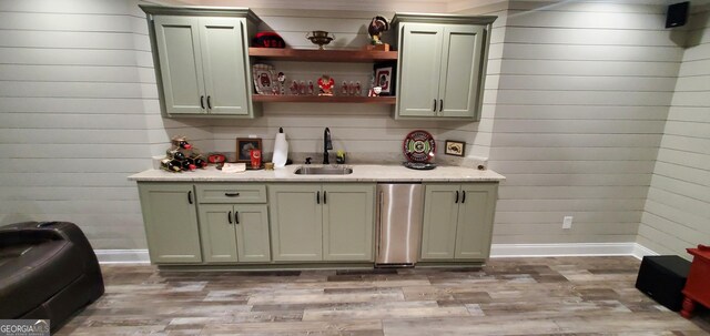 1030 Lake Haynes Dr NE, Conyers, GA 30012 - bar with light wood finished floors, baseboards, wood walls, and a sink