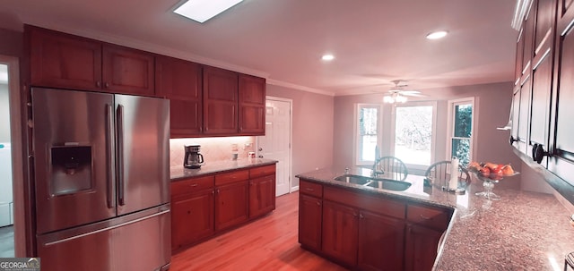 kitchen featuring sink, stainless steel fridge with ice dispenser, light stone counters, crown molding, and light wood-type flooring