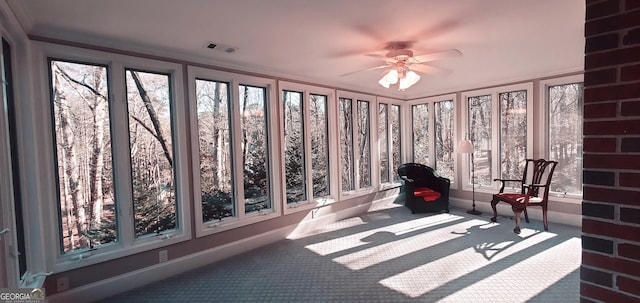 unfurnished sunroom with ceiling fan