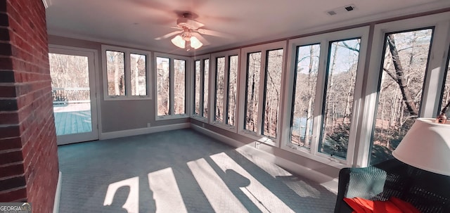 unfurnished sunroom with ceiling fan