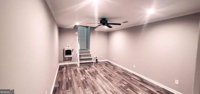 unfurnished living room with heating unit, ceiling fan, crown molding, and hardwood / wood-style flooring