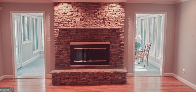 1030 Lake Haynes Dr NE, Conyers, GA 30012 - details featuring a fireplace, wood finished floors, baseboards, and ornamental molding