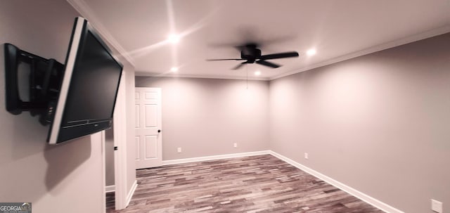 spare room with wood-type flooring, ceiling fan, and crown molding