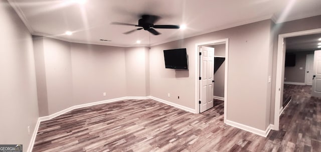 basement featuring dark hardwood / wood-style flooring, ceiling fan, and ornamental molding