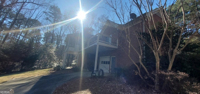 view of side of home featuring a garage and a balcony