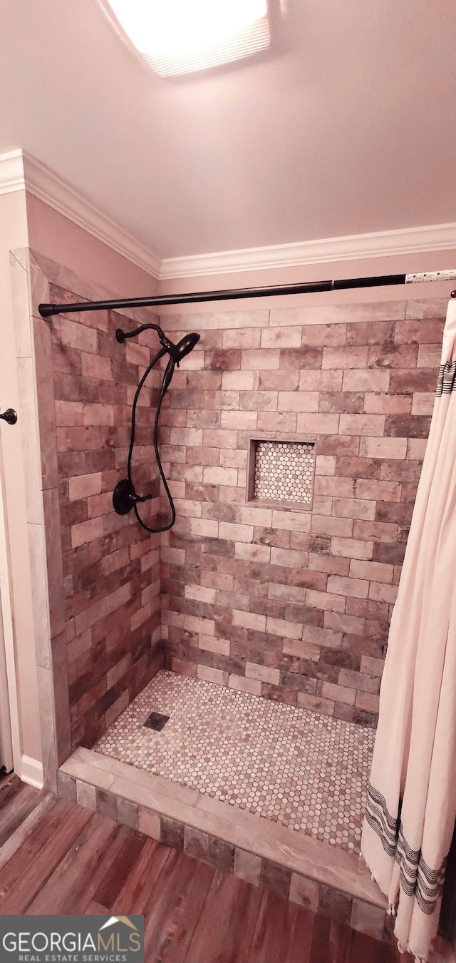 bathroom featuring a shower with shower curtain, hardwood / wood-style floors, and ornamental molding