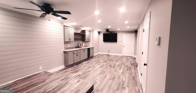 kitchen featuring ceiling fan, sink, stainless steel dishwasher, and light hardwood / wood-style flooring