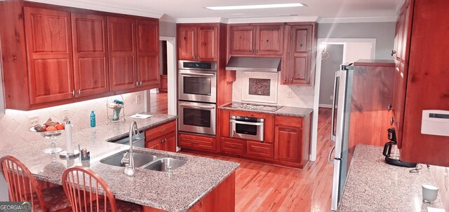 1030 Lake Haynes Dr NE, Conyers, GA 30012 - kitchen with a peninsula, a sink, light wood-type flooring, extractor fan, and appliances with stainless steel finishes