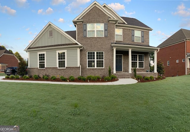 craftsman-style house featuring covered porch and a front yard