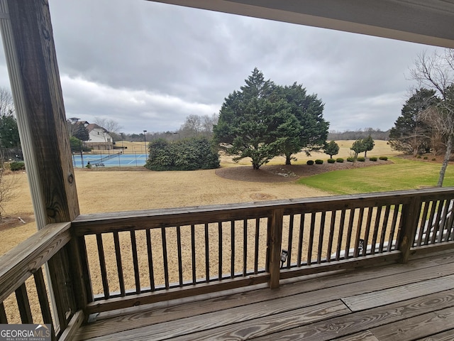 deck with tennis court and a lawn