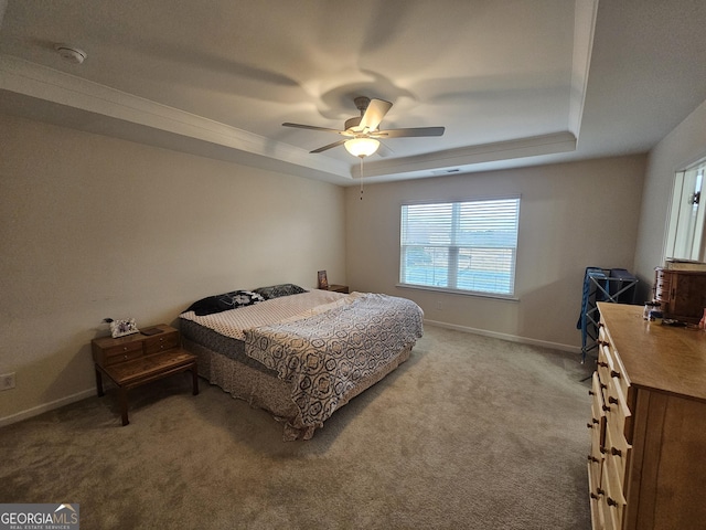 bedroom featuring ceiling fan, a tray ceiling, and carpet floors