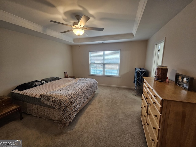 carpeted bedroom with ceiling fan and a tray ceiling