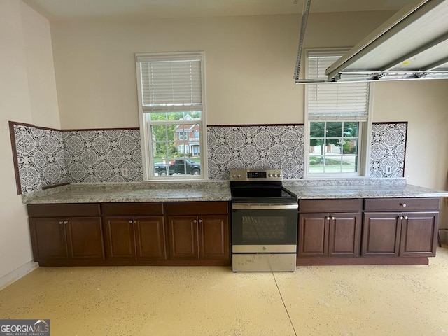 kitchen featuring dark brown cabinets, stainless steel electric range oven, and plenty of natural light