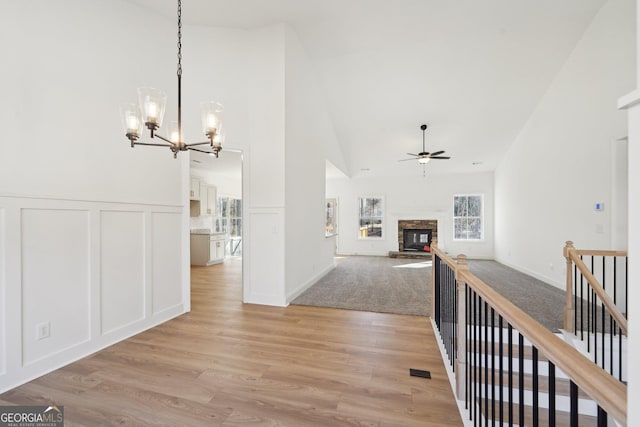 corridor featuring vaulted ceiling, an inviting chandelier, and light hardwood / wood-style floors