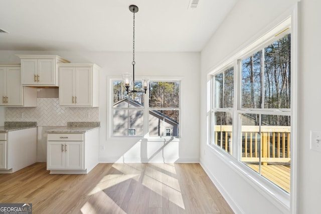 dining area featuring an inviting chandelier and light hardwood / wood-style floors