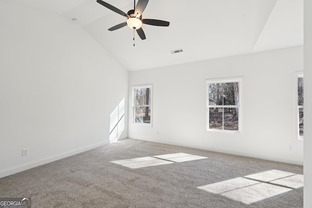 empty room featuring vaulted ceiling, ceiling fan, and carpet flooring