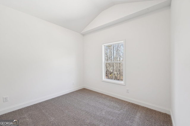 carpeted empty room with lofted ceiling