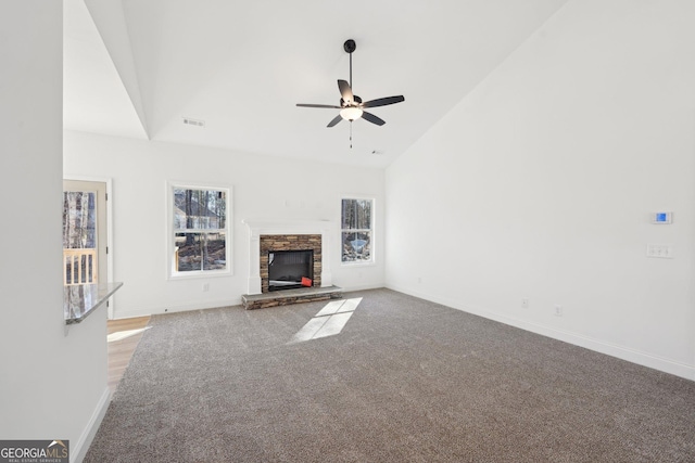 unfurnished living room with ceiling fan, high vaulted ceiling, carpet flooring, and a fireplace