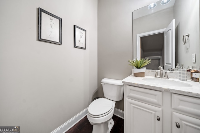 bathroom with toilet, wood-type flooring, and vanity