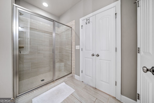 bathroom with an enclosed shower and tile patterned floors