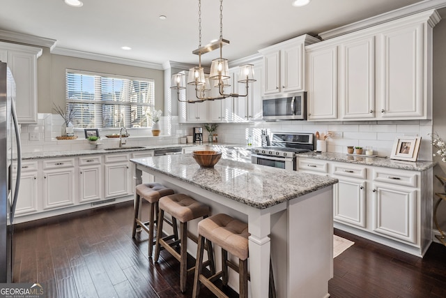 kitchen featuring a kitchen island, stainless steel appliances, white cabinets, and sink