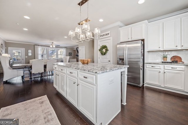 kitchen with white cabinets, ceiling fan, a center island, and stainless steel refrigerator with ice dispenser